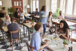 Customers Enjoying Meals In Busy Restaurant